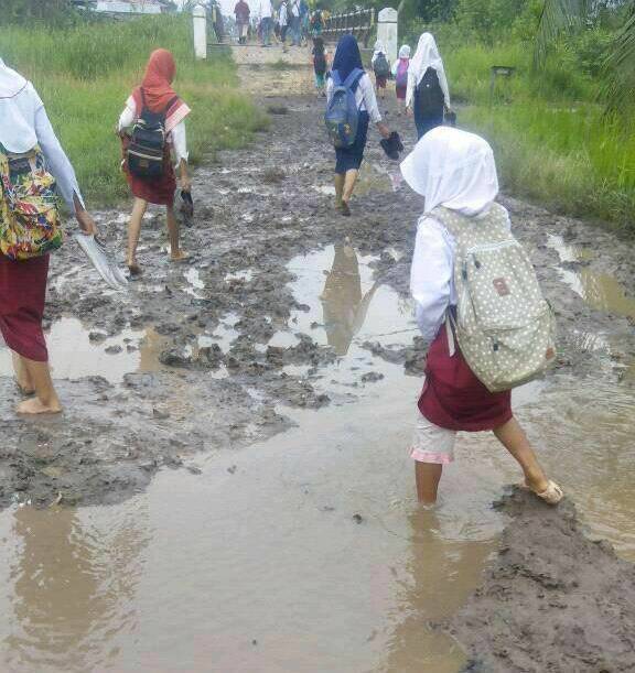 Anak Sekolah Lintasi Jalan Berlumpur