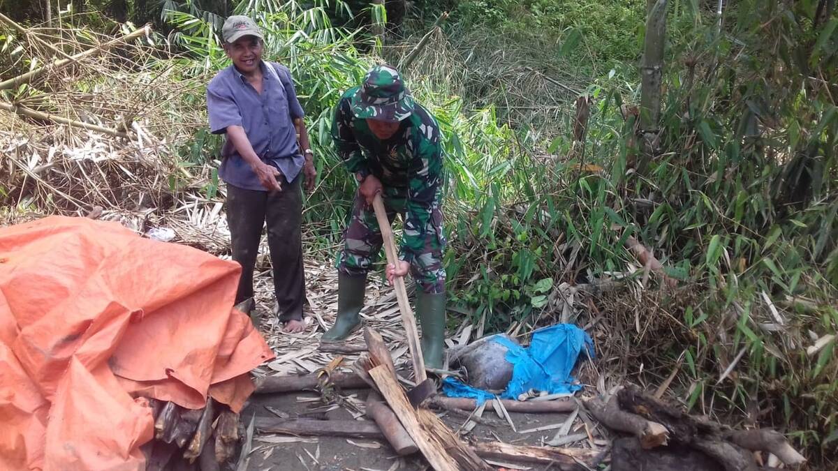 Anggota Satgas TMMD ke 104 Kodim 0417/Kerinci Membantu Warga Memotong Kayu Bakar