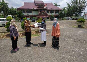 Nining Antero menyerahkan bantuan ke petugas. Foto: Istimewa