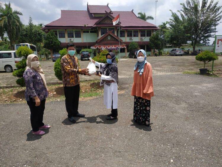 Nining Antero menyerahkan bantuan ke petugas. Foto: Istimewa