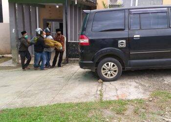 Warga membawa pasien reaktif rapid test Covid-19 yang meninggal dunia. Foto: Gandi