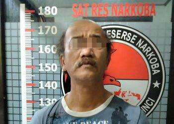 Tersangka DR saat berada di kantor polisi. Foto: Gandi