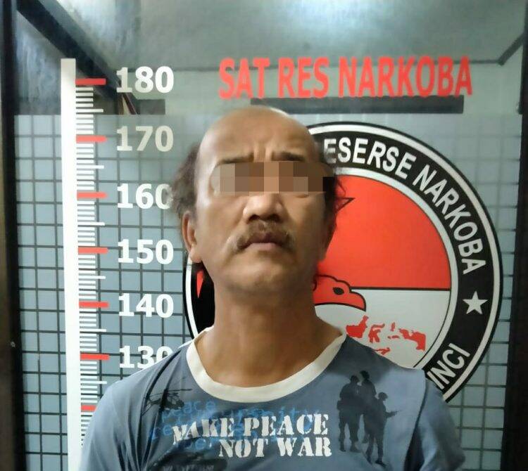 Tersangka DR saat berada di kantor polisi. Foto: Gandi
