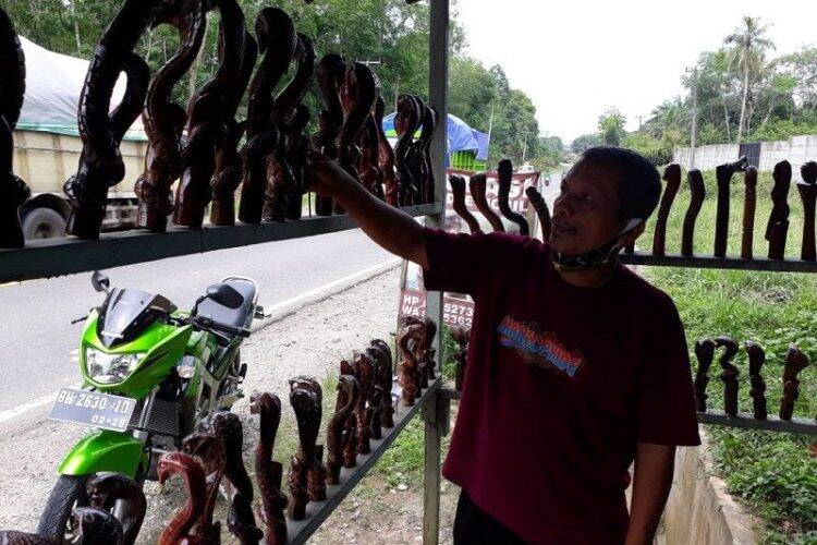 Yulianis (54) alias Uda Handel di bengkel ukirnya memajang handel tuas perseneling berbentuk ular kobra