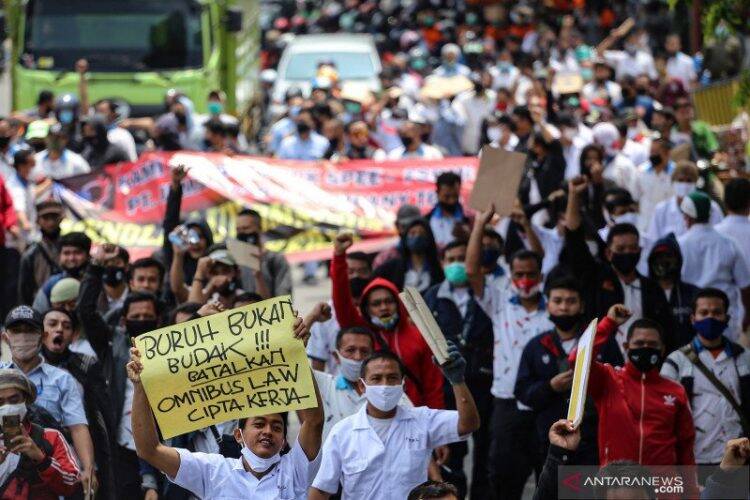 Sejumlah buruh mengikuti aksi long march di kawasan Jatiuwung, Kota Tangerang, Banten, Selasa (6/10/2020). Aksi tersebut sebagai bentuk kekecewaan buruh atas pengesahan Undang-Undang Cipta Kerja yang dianggap merugikan kaum buruh