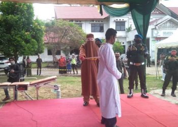 Seorang terpidana pelanggaran syariat Islam saat menjalani hukuman cambuk di di depan Kantor Dinas Syariat Islam Aceh Timur