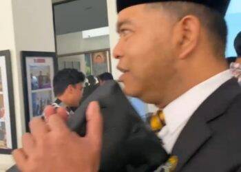 Tampang Wajah Amrizal Jelang Diperiksa Polda Jambi, Mata Sembab Pakai Peci-Jas Hitam, Pegang Tas Handbag Melipat Tangan